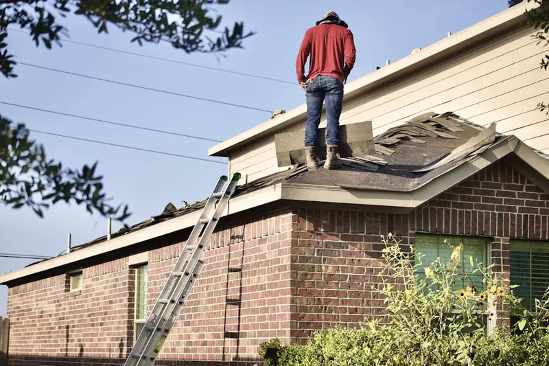 Professional roofer working on a residential roof in Mercy Drive